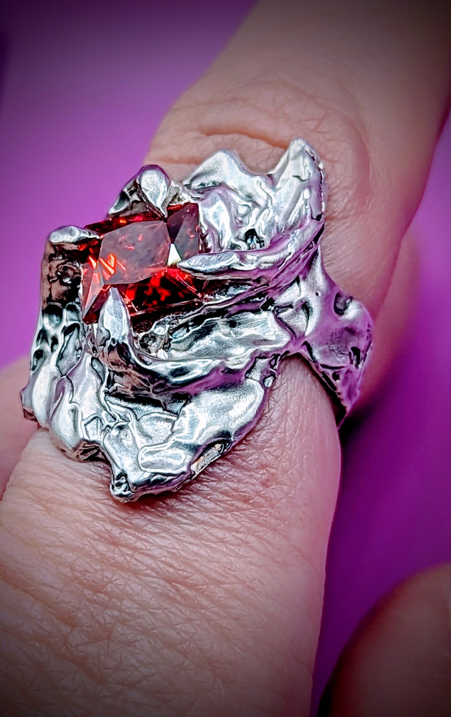 Side view of Fusion ring – molten silver and dark gemstone in sculpted design