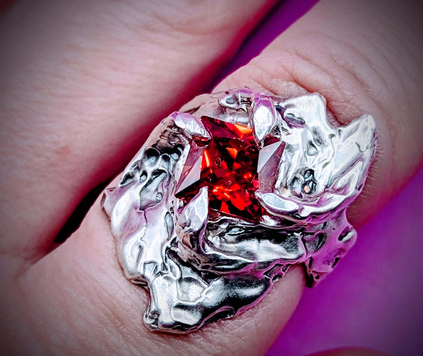 Detailed shot of clawed silver setting with garnet – handcrafted from wax model