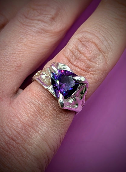 Hand-carved silver ring with flowing shape and purple gem – elegant handmade design