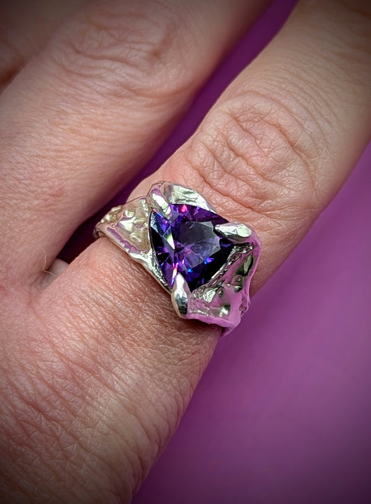 Hand-carved silver ring with flowing shape and purple gem – elegant handmade design