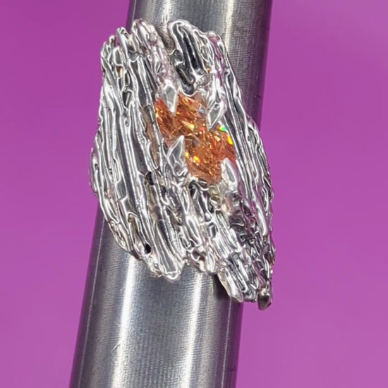 Close-up video of handmade silver ring on mandrel – bark-textured band with champagne CZ