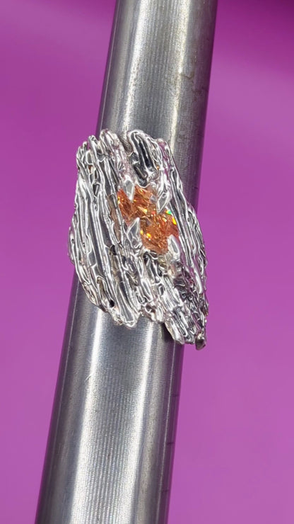 Close-up video of handmade silver ring on mandrel – bark-textured band with champagne CZ