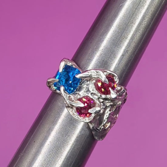 Close-up video of handmade silver ring on mandrel – textured claws with pink and blue nano gems